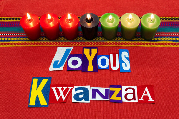 JOYOUS KWANZAA texto palabra collage tipografía, con siete velas y tela multicolor en tela tejida roja, fiesta afroamericana, aspecto horizontal
 - Foto, Imagen