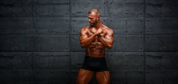 Симпатичный мужской фитнес-модель позирует, сгибает мышцы
 - Фото, изображение