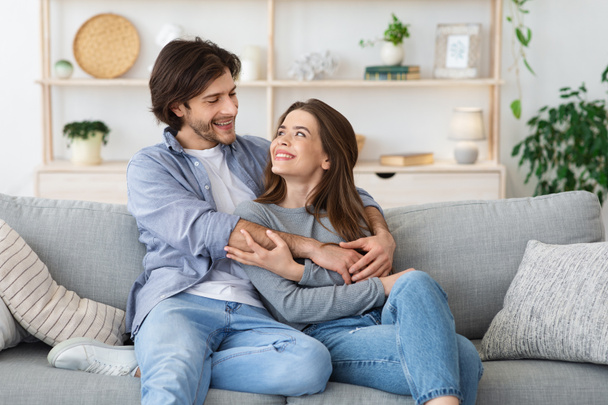 Preciosa pareja joven abrazándose en su sala de estar
 - Foto, imagen
