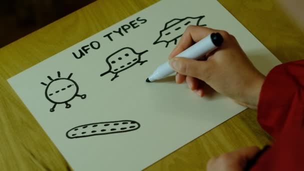 女の子は紙に様々なUFOを描きます - 映像、動画