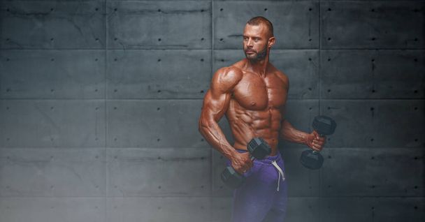 Vahva lihaksikas miesten liikunta painoilla. Kehonrakentaja tekee Bicep käsipaino kiharat
 - Valokuva, kuva