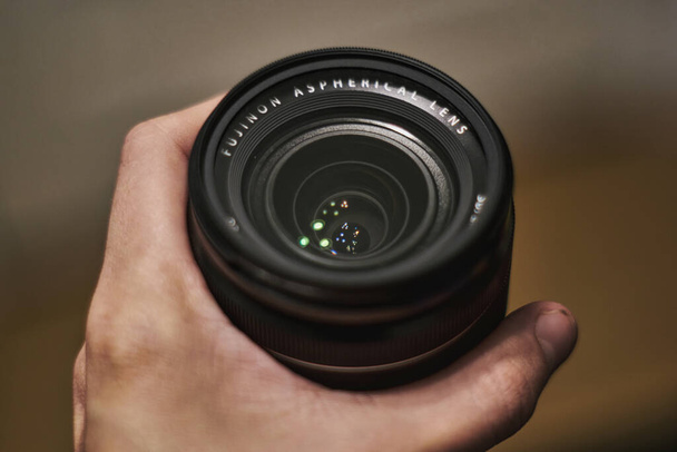 Close up hand holding fujifilm lens. - Photo, Image