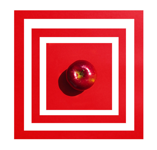 красивое геометрическое яблоко на красном mfon в рамке. Концепция диеты, вид сверху
 - Фото, изображение