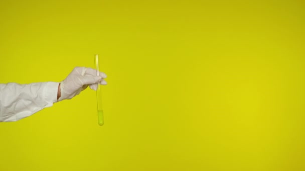 Mão na proteção luva de látex mostra um tubo de vidro com a substância
 - Filmagem, Vídeo