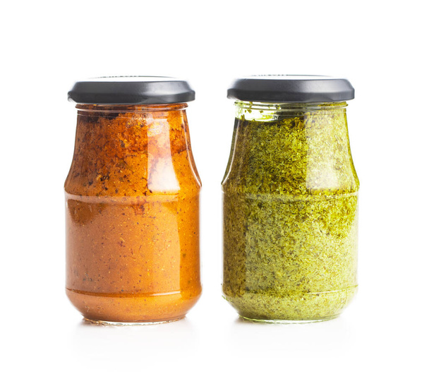 Green basil and red tomato pesto dip sauce in jar isolated on white background. - Foto, immagini