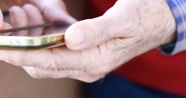 close-up das mãos da pessoa idosa manuseando um smartphone
 - Filmagem, Vídeo