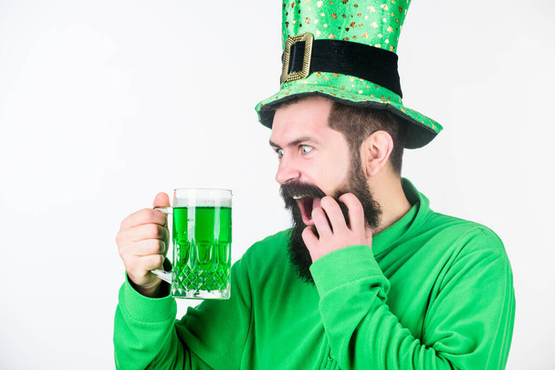 Irish for a day. Bearded man toasting to saint patricks day. Irish man with beard drinking green beer. Celebrating saint patricks day in bar. Hipster in leprechaun hat holding beer mug - Zdjęcie, obraz