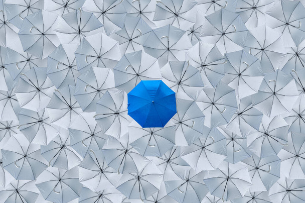 Un paraguas azul normal es diferente de los paraguas grises de vuelco, Al ser diferentes conceptos, Concepto de negocio, Líder, Paraguas azul puede proteger la lluvia, Paraguas grises no puede proteger la lluvia, Vista superior. - Foto, imagen