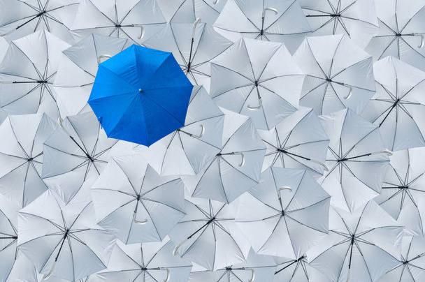 A normal blue umbrella is different from the overturn grey umbrellas, Being different concepts, Business concept, Leader, Blue umbrella can protect rain, grey umbrellas can't protect rain, Top view. - Photo, Image