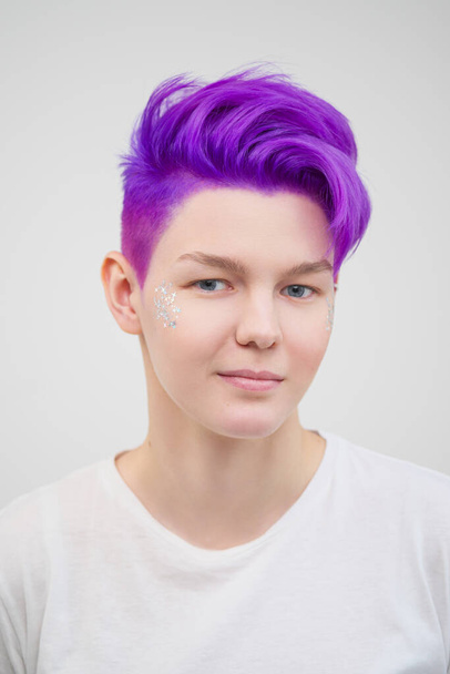 Portrait of a young attractive woman in a white T-shirt on a white background. Purple-colored short hair. - Fotoğraf, Görsel