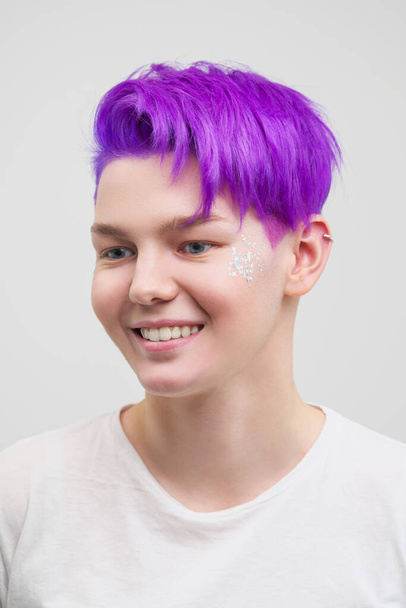 Portrait of a young attractive woman in a white T-shirt on a white background. Purple-colored short hair. - Photo, image