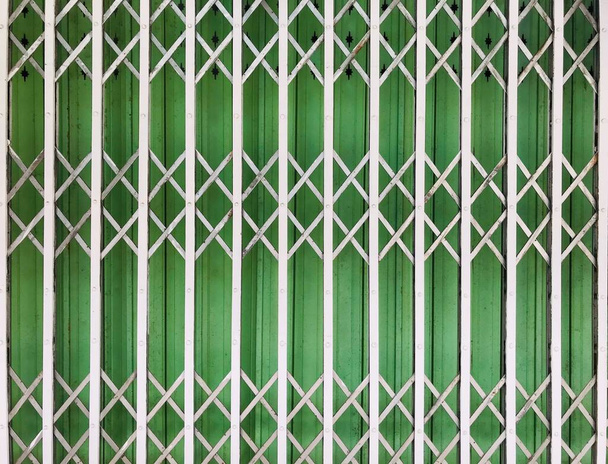 białe stalowe drzwi składane z zieloną blachą tło w pełnym kadrze strzał, stosowane na tle - Zdjęcie, obraz