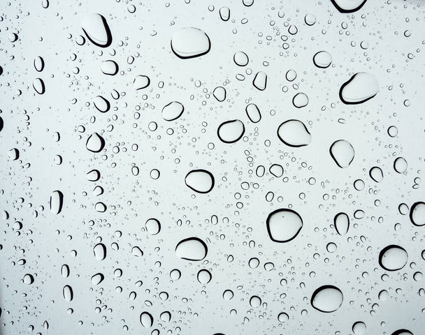 Σταγόνα νερού σε γυάλινο φόντο. Νερό σταγόνες υφή στο παρμπρίζ τις βροχερές ημέρες. - Φωτογραφία, εικόνα