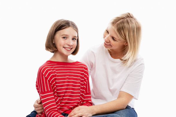 Daughter teenager and mother laugh and hug. Love and support in family relationships. White background. Space for text. - 写真・画像
