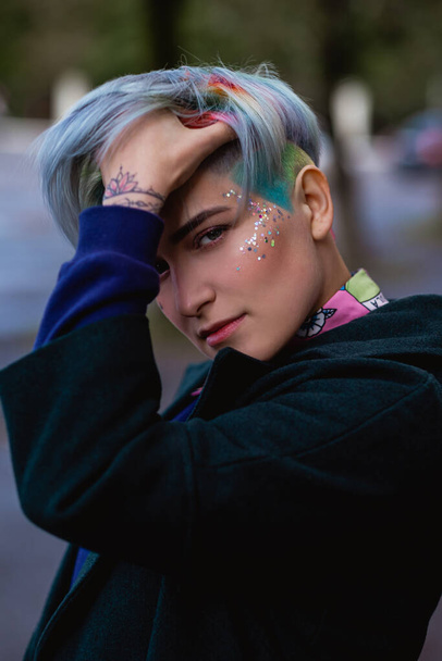Portrait of a young beautiful woman with a short haircut and dyed hair. Grey main color and yellow, green, blue and red hair color. - Photo, Image