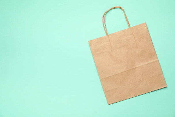 Blank paper bag on mint background, space for text - Φωτογραφία, εικόνα