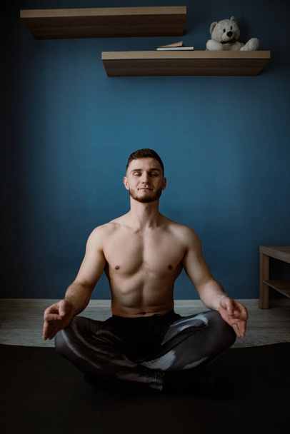 guy meditating on a floor at home - Photo, Image