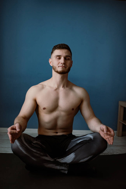 guy meditating on a floor at home - Foto, afbeelding