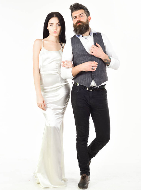 Couple in love, bride and groom in elegant wedding clothes, white background. Woman in wedding dress and man in vest. Wedding concept. Bearded hipster with bride dressed up for wedding ceremony. - Fotografie, Obrázek