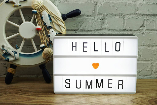 Hello Summer word in light box on white brick wall and wooden background - Φωτογραφία, εικόνα