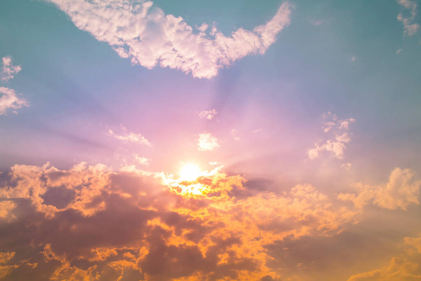 luz solar laranja com luz de raio roxo no céu verde azul com nuvens
 - Foto, Imagem