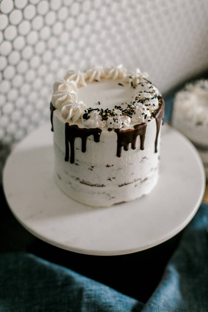 Jedno warstwowe ciasto z polewą waniliową i polewami czekoladowymi na wierzchu - Zdjęcie, obraz