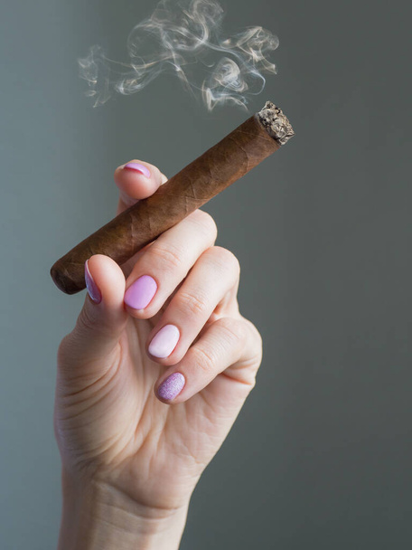 Кубинська сигара в руках. Жінка тримає палаючу сигару. - Фото, зображення