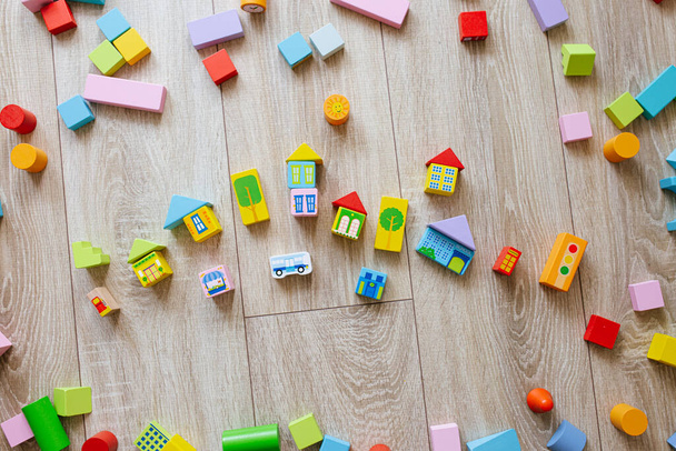 Colorful wooden building blocks on floor children room. Selective focus - Fotó, kép