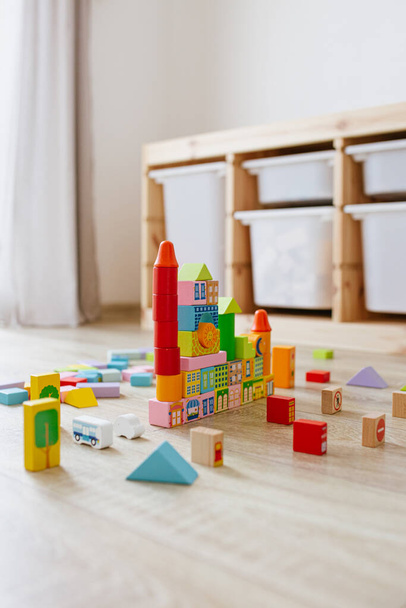 Colorful wooden building blocks on floor children room. Selective focus - Fotó, kép