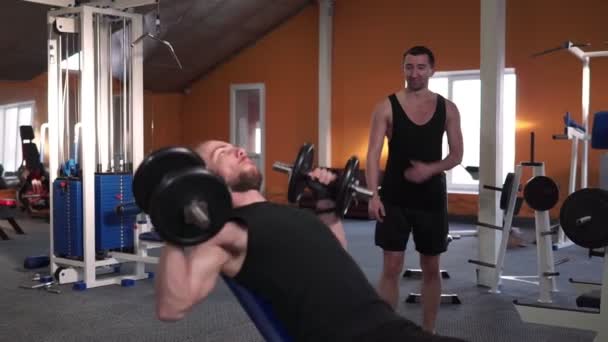 Sterke man die gewicht tilt in de sportclub. Close-up man training spieren met halters in de sportschool. - Video
