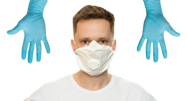 Young surgeon doctor in latex protective gloves in white protection mask on white background. Man in medical gloves and on protective face mask. Coronavirus COVID-19 protectio - Фото, зображення