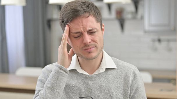 Πονοκέφαλος, κουρασμένος νεαρός άνδρας που έχει πόνο στο κεφάλι - Φωτογραφία, εικόνα