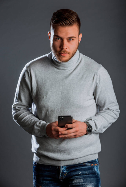 Πορτραίτο μόδας στούντιο ενός νεαρού άνδρα που φοράει μάλλινο πουλόβερ πόλο - Φωτογραφία, εικόνα