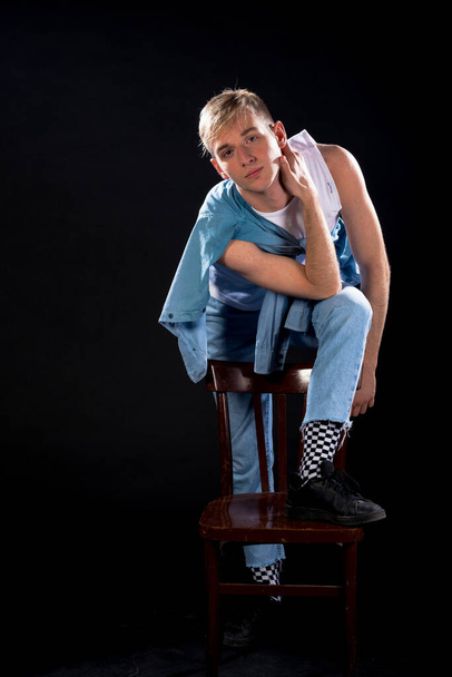 Студийный портрет красивого парня в синих джинсовых брюках и белом топе
 - Фото, изображение