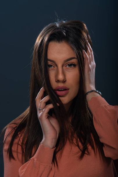 Close up retrato de bela jovem modelo feminino com blusa laranja no fundo preto - Foto, Imagem