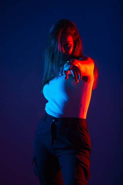 Modelo feminino posando em estúdio com cores vermelho e azul em alto contraste. - Foto, Imagem