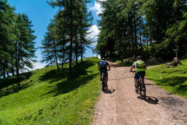 Two mountain bikers on a mountain trail with a scenic view on a sunny day - Fotografie, Obrázek