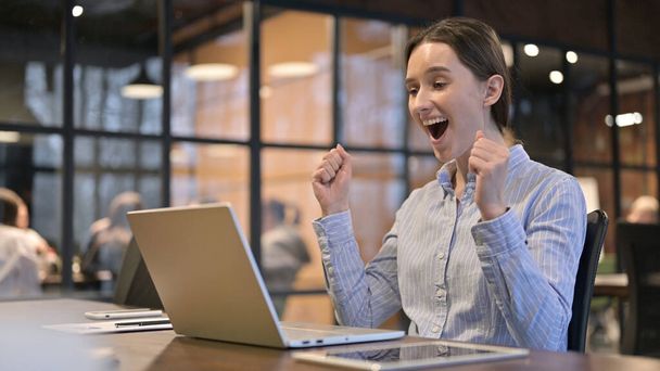 Jeune femme excitée célébrant le succès sur ordinateur portable
 - Photo, image