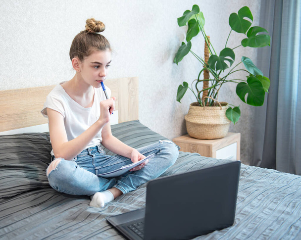 Schoolmeisje die thuis studeert met een laptop. Blijf thuis. Online onderwijs, thuisonderwijs, quarantaine concept. - Foto, afbeelding