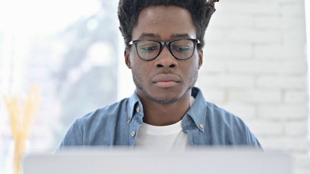 Retrato de un joven africano trabajando en un ordenador portátil
 - Foto, Imagen