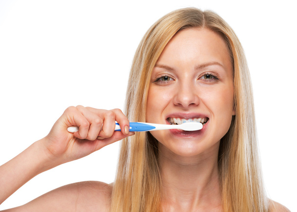 Portrait of teenage girl brushing teeth - 写真・画像