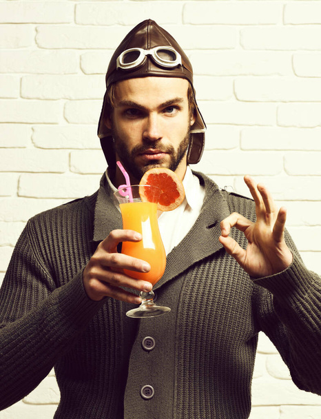 bearded pilot with cocktail in glass on white brick wall background - Zdjęcie, obraz