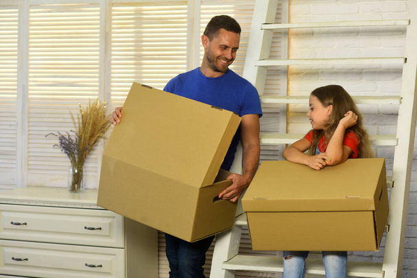 Daughter and father hold boxes and unpack. Moving and family - Φωτογραφία, εικόνα