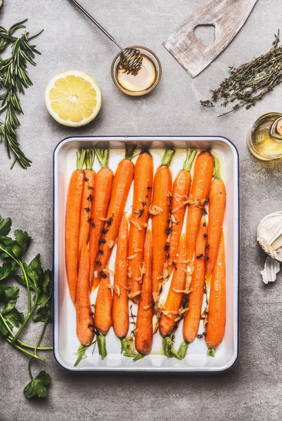 Roasted Carrots with thyme, garlic, lemon and honey on baking try , cooking preparation. Healthy root vegetables concept - Foto, imagen