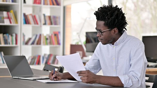 Paperwork by African Man in Office - Фото, зображення