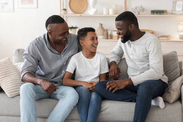 Preteen african boy spending time at home with grandfather and dad - Photo, Image