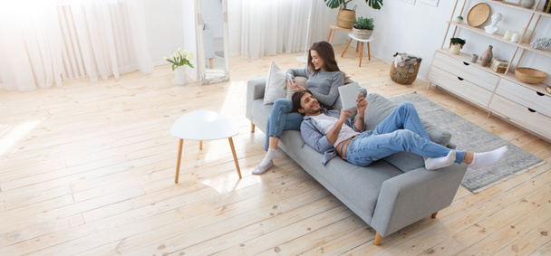 Mladá rodina dvou relaxačních na pohovce doma - Fotografie, Obrázek