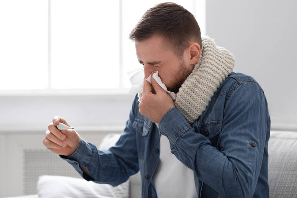Chory człowiek z gorączką dmuchający swój katar w domu - Zdjęcie, obraz