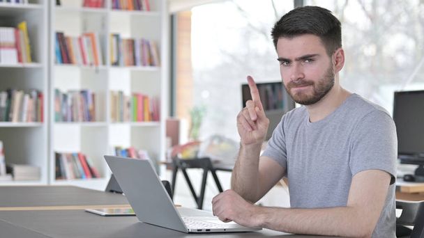 No Finger Sign by Young Man with Laptop in Office - Foto, Bild