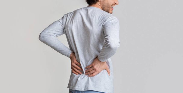 Kidney pain concept. Man presses hands to his back - Zdjęcie, obraz